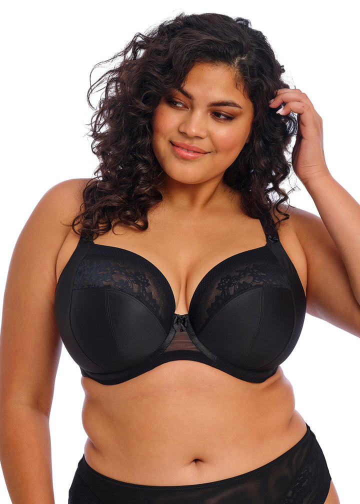 Woman wearing a black bra and underwear set on a white background