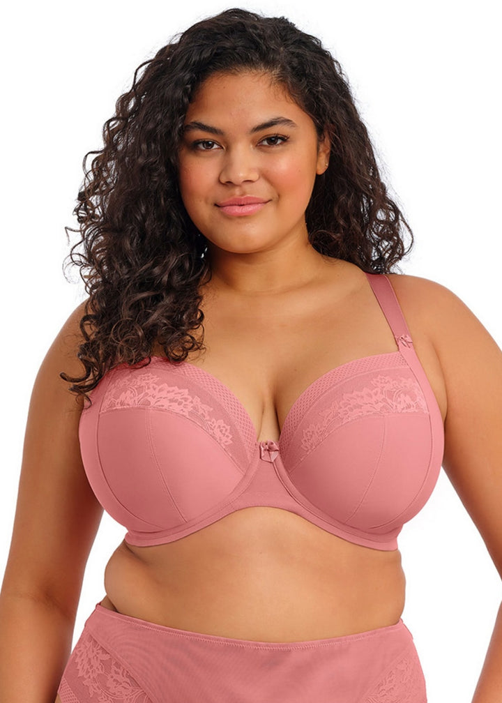 Woman wearing a pink bra and underwear set on a white background