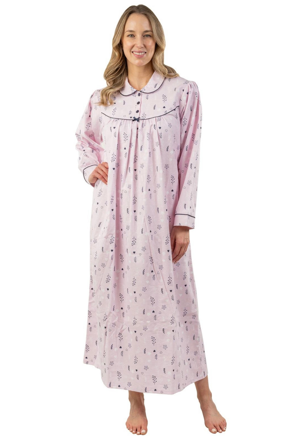 Woman wearing a long pink floral cotton nightgown with Peter Pan collar and navy trim