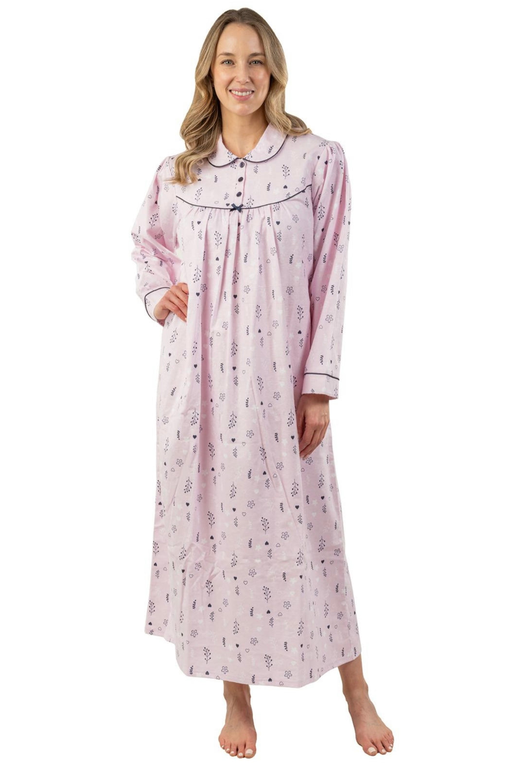 Woman wearing a long pink floral cotton nightgown with Peter Pan collar and navy trim