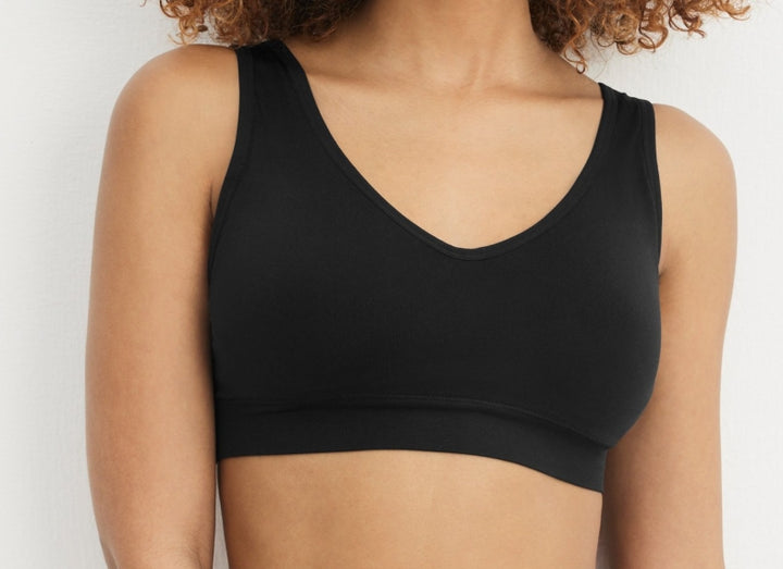 Black sports bra worn by a person on a light gray background