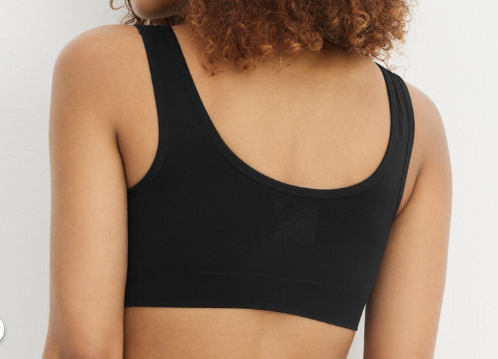 Person wearing a black sports bra against a plain background
