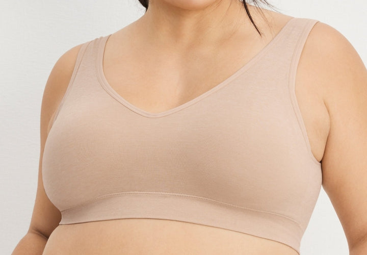 Beige bra worn by a person on a light gray background