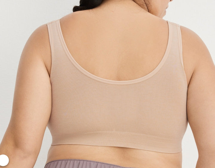 Beige tank top worn by a person on a plain background