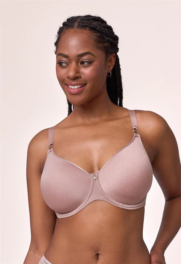 Woman wearing a pink bra against a beige background