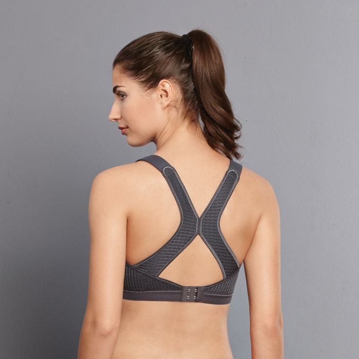 Woman wearing a gray sports bra against a gray background