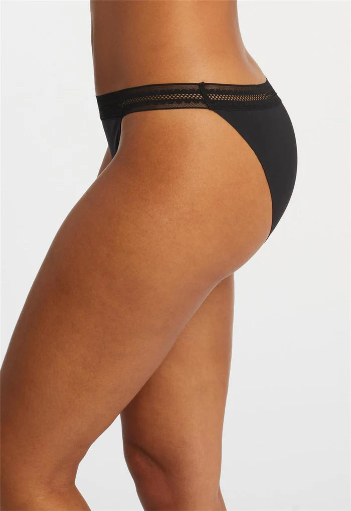 Black underwear worn by a person on a light gray background