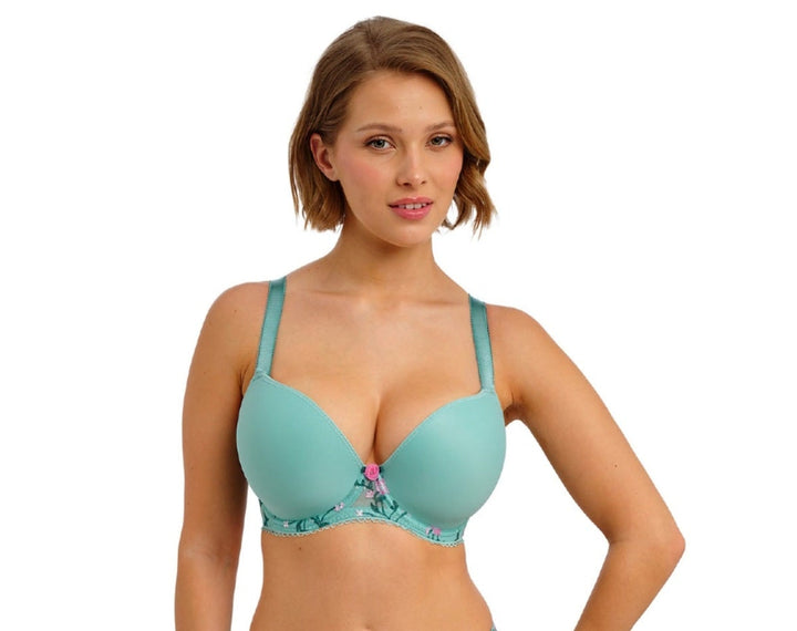 Woman wearing a teal bikini with floral details on a white background