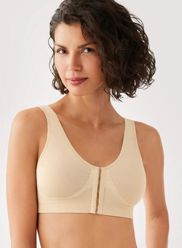 Woman wearing a beige bralette against a plain background