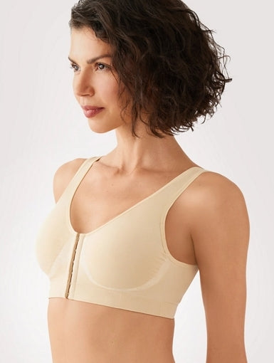 Woman wearing a beige bra against a plain background