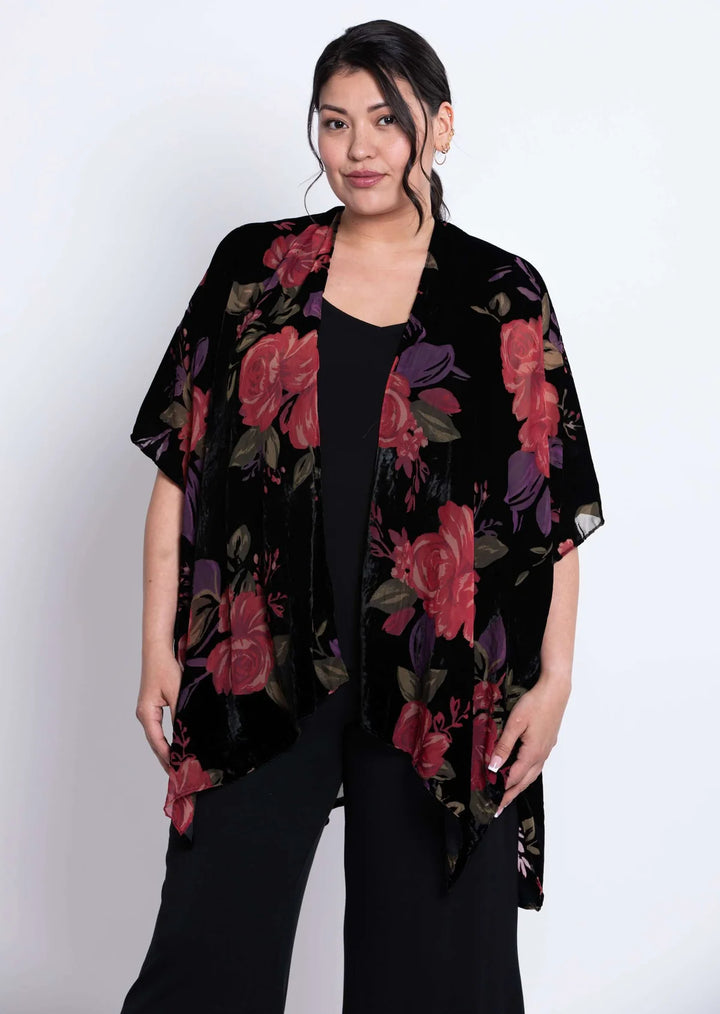 Woman wearing a black floral kimono against a white background