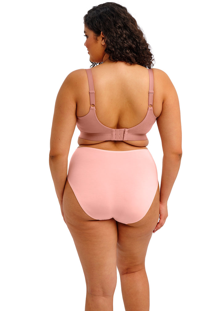 Woman wearing a pink swimsuit with a bow detail on a white background