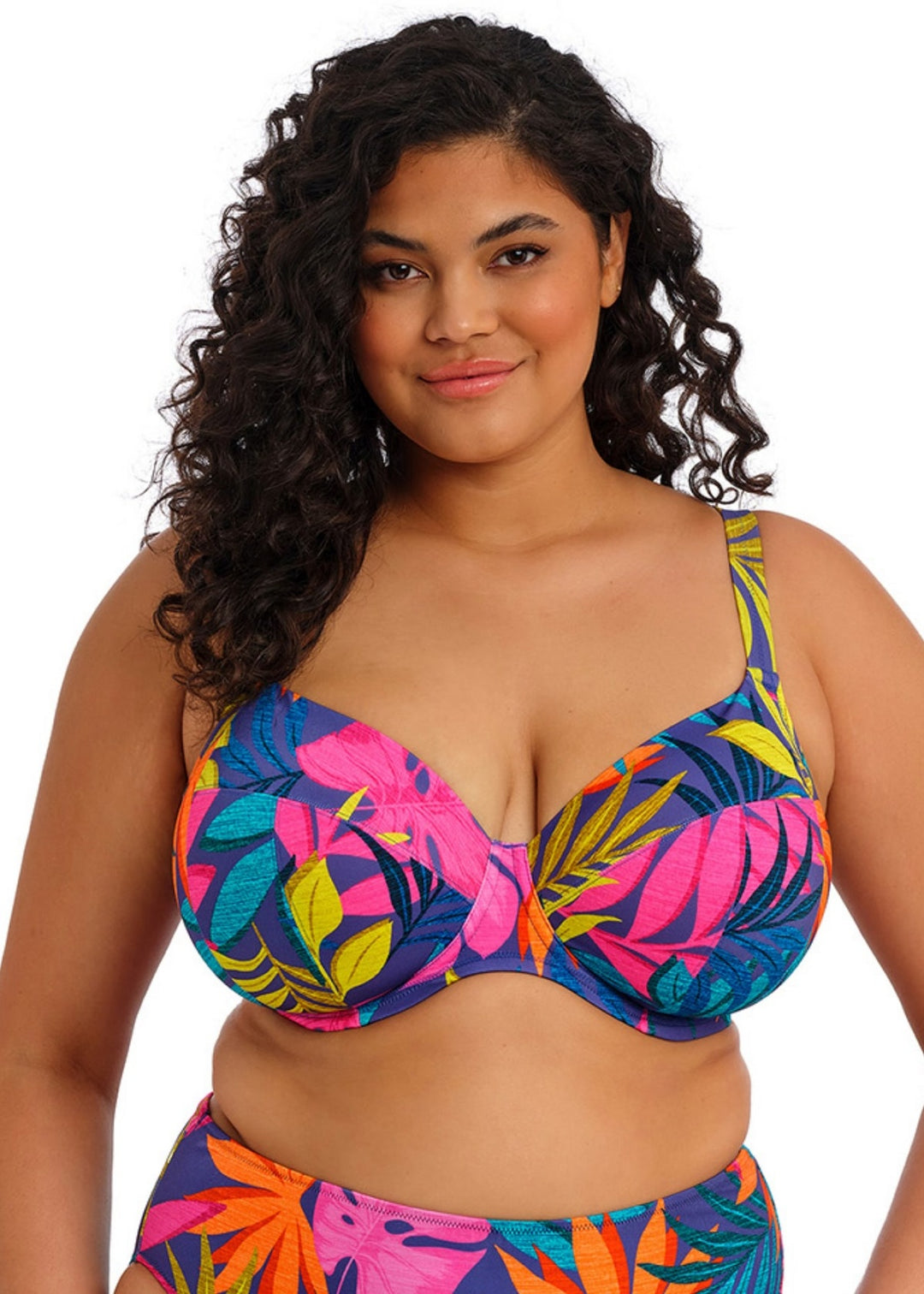 Woman wearing a colorful tropical print bikini on a white background