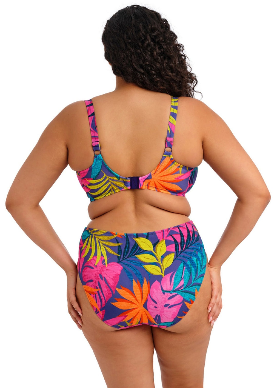 Woman wearing a colorful tropical print bikini set on a white background