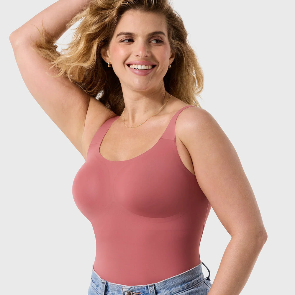 Woman wearing a pink tank top against a plain background