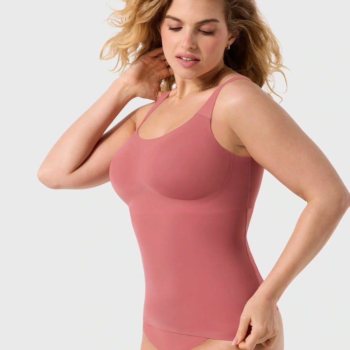 Woman wearing a pink tank top against a light gray background
