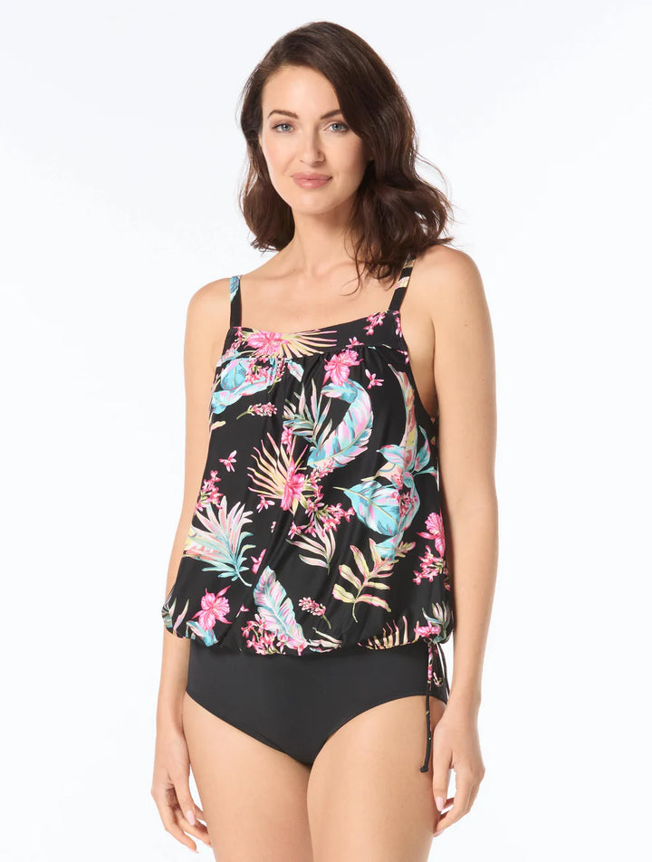 Woman wearing a black tankini with colorful floral pattern on a white background