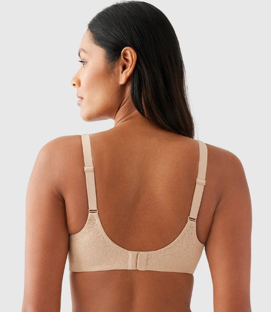 A woman shown from the back wearing a beige underwire bra with wide shoulder straps and a seamless lace-like cup texture, against a light gray studio background.