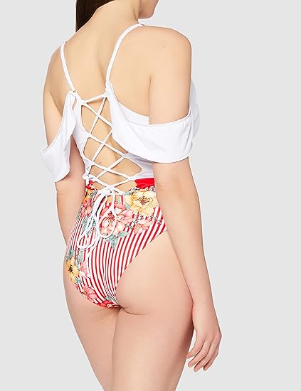 Woman wearing a white top and colorful striped swimsuit with floral details on a light gray background
