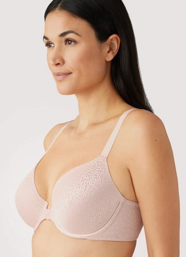 Woman wearing a light pink textured bra against a plain background