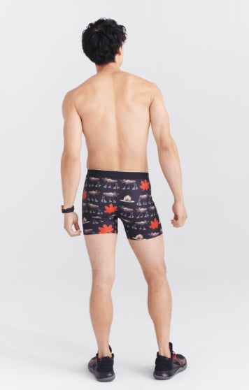 Man wearing patterned swim shorts on a white background