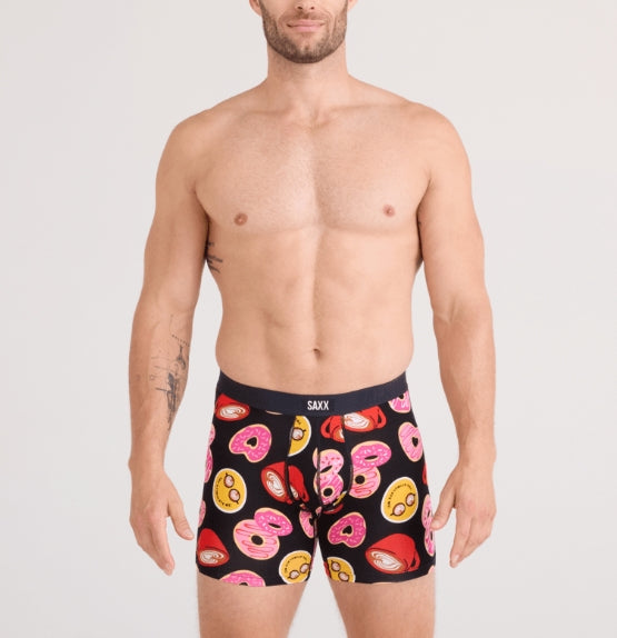 Man wearing SAXX donut patterned underwear on a plain background