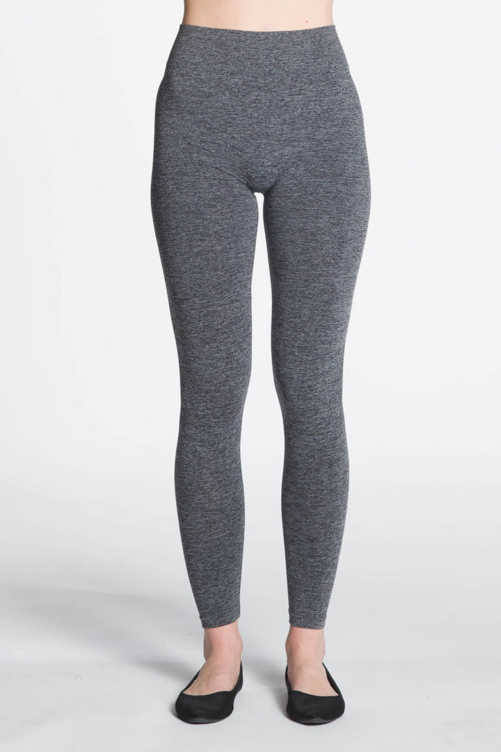 Gray leggings worn by a person on a white background