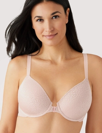 Woman wearing a light pink bra against a white background