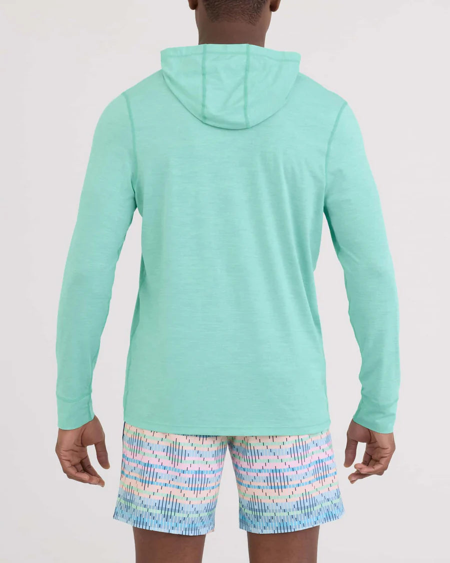 Person wearing a light blue hoodie and patterned shorts on a white background