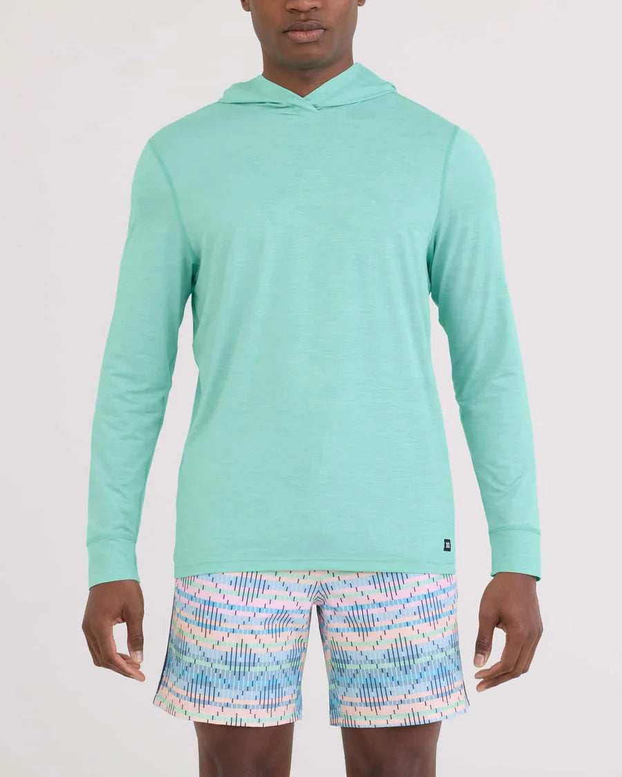 Person wearing a light blue hoodie and patterned shorts on a white background