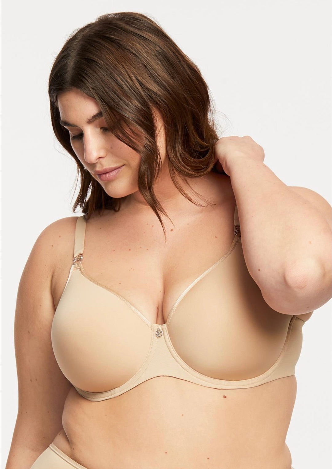 A woman wearing a beige Montelle Sublime Spacer Bra, which offers full support and coverage.
